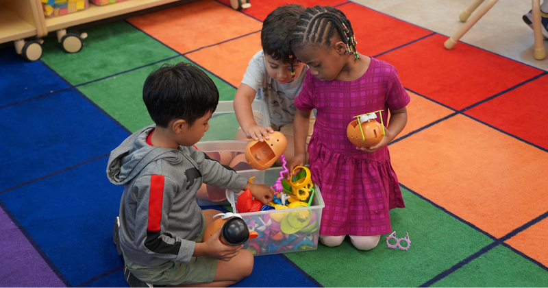 three students play with a potato character