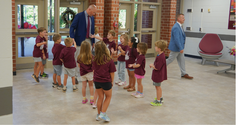 pre-k and kindergarten students greet visitors to the school