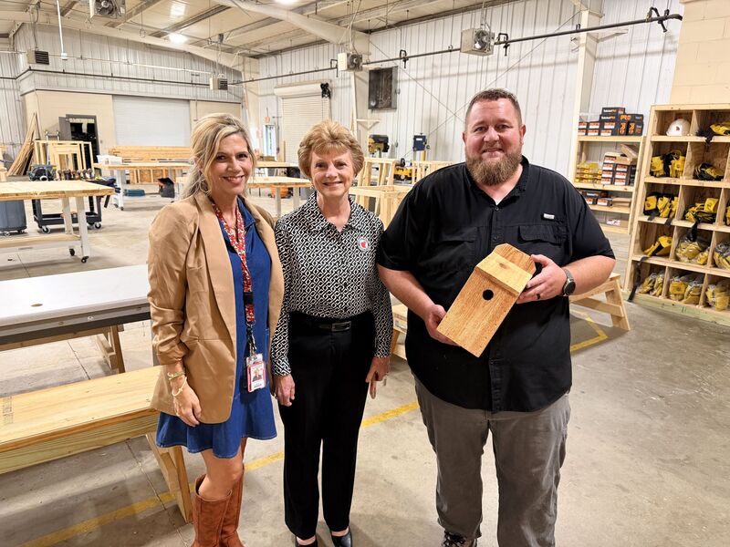 three people pose in a construction lab