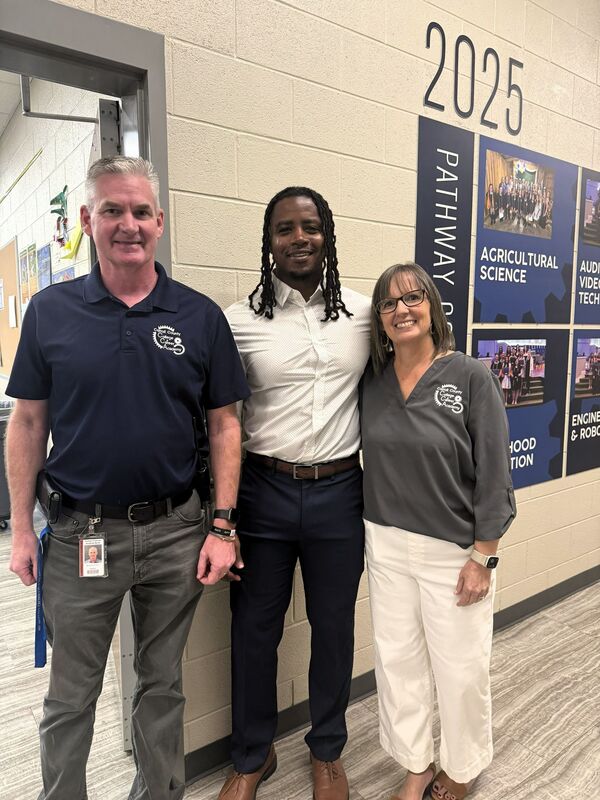 three people post in the hallway of CCA North