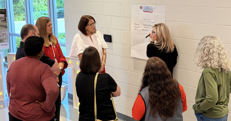a group shares ideas for improvement which are captured on a large piece of paper
