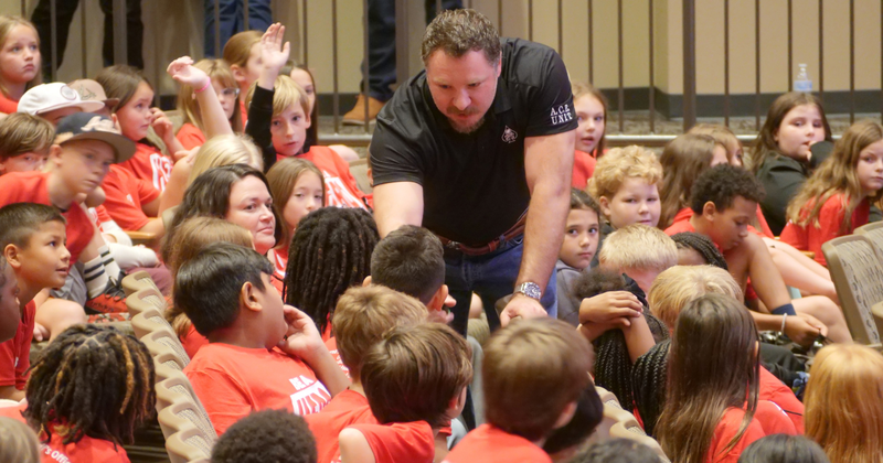 a man holds a microphone toward a child to speak