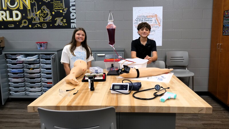 two students pose with a phlebotomy demonstration