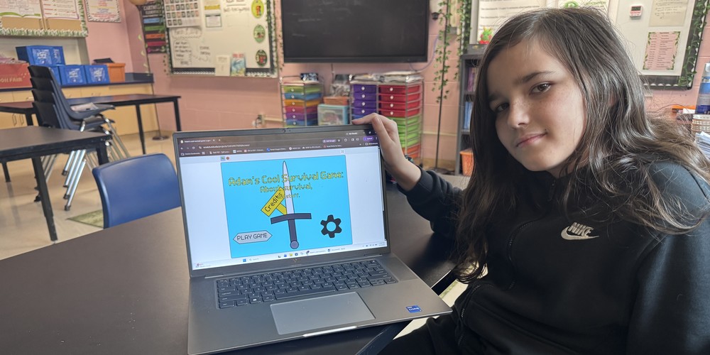 student showing computer game he created