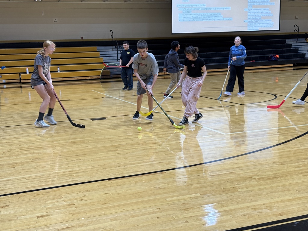 Students learning field hockey.