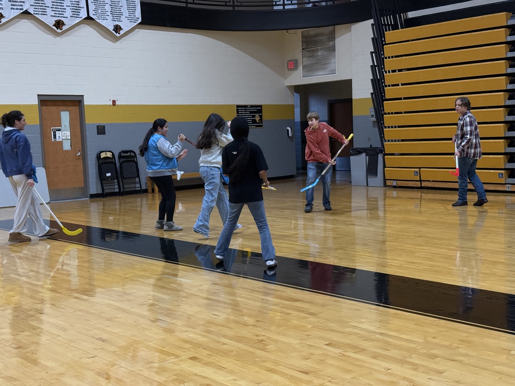Students learning field hockey.