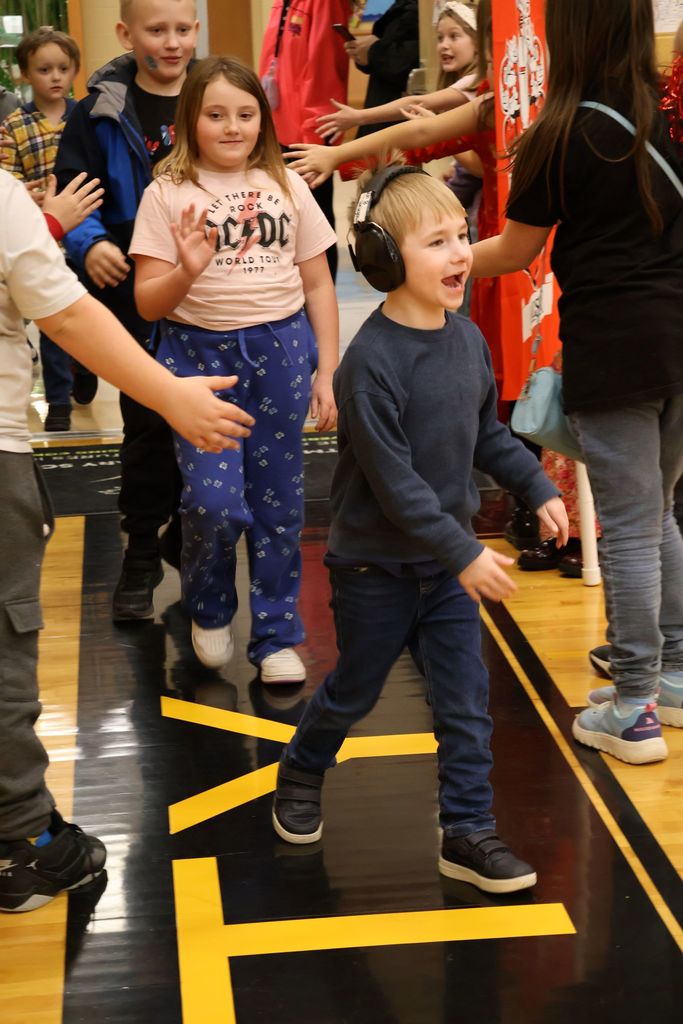 student cheering as he enters the gym