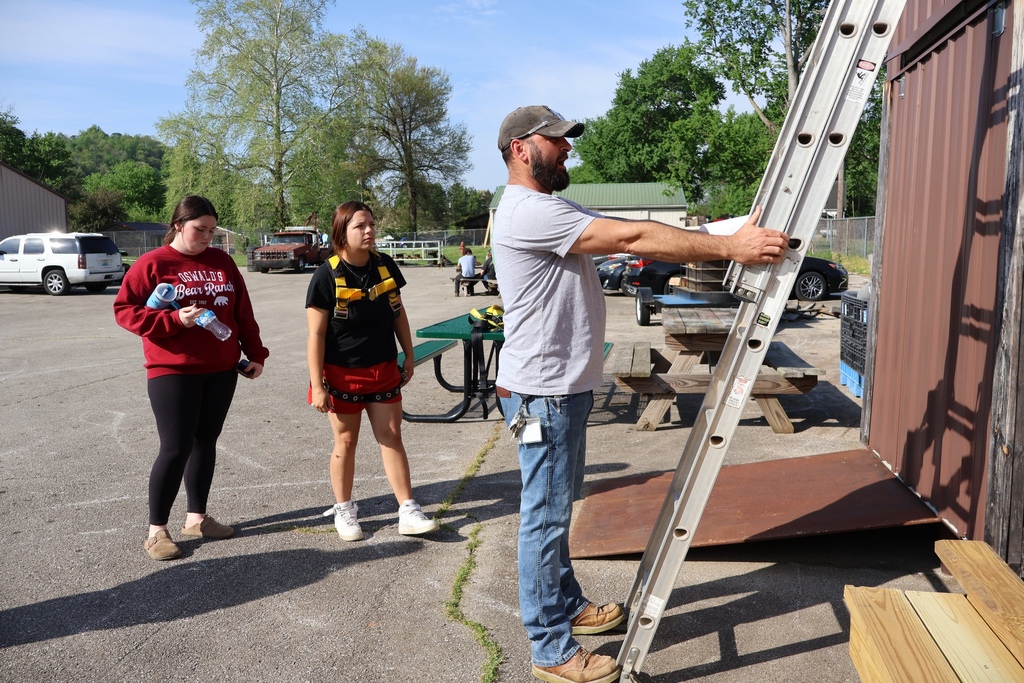 Teacher demonstrating how to position ladder