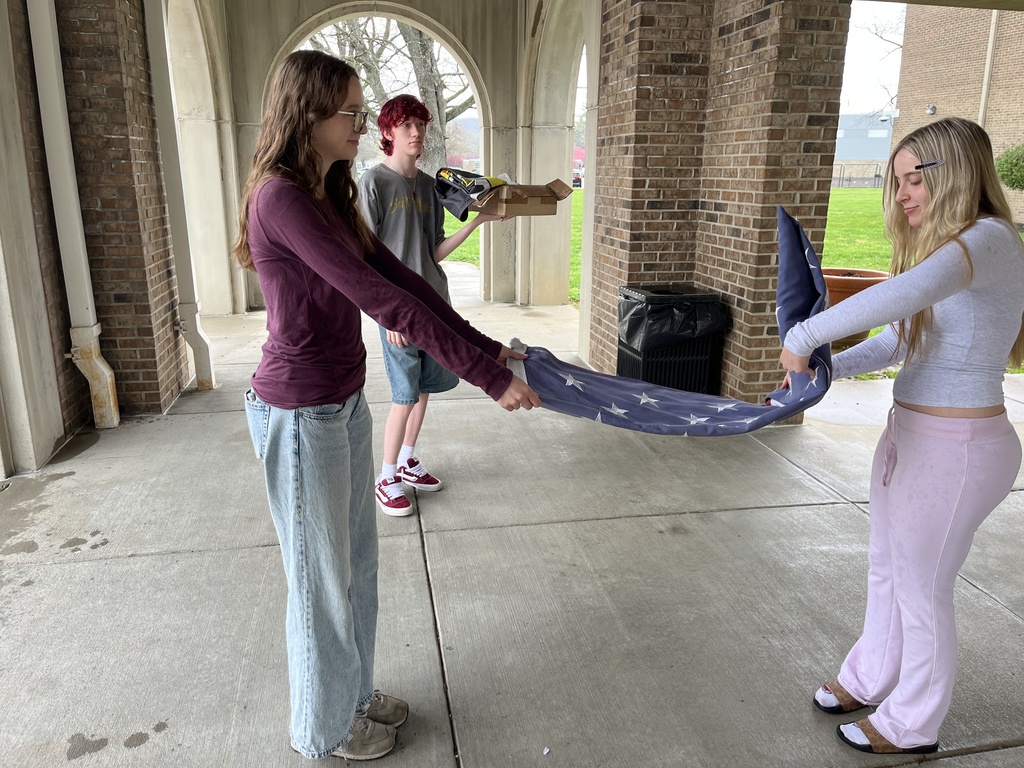 students folding flag
