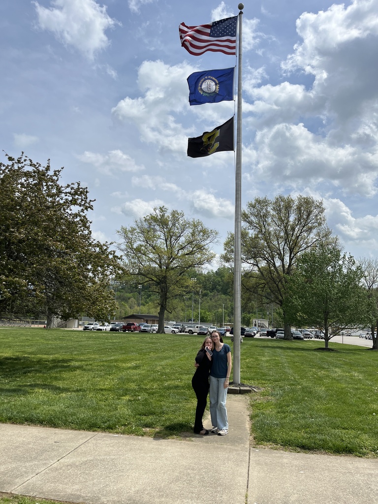 students in front of flag pole