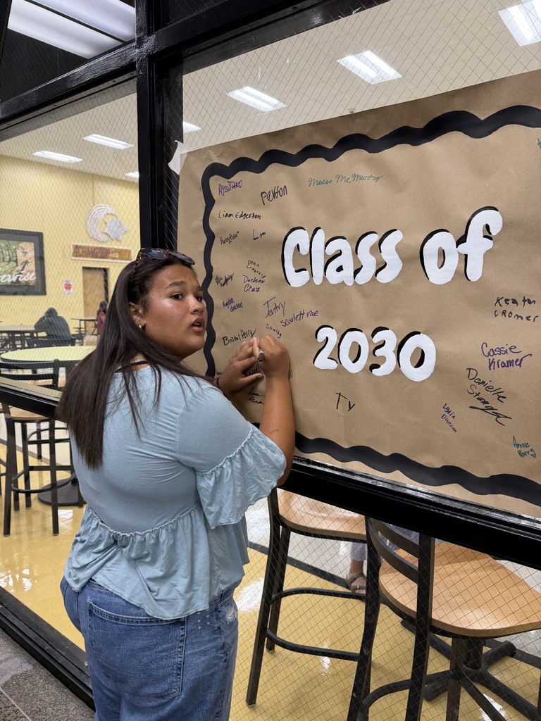 Student signing name on banner
