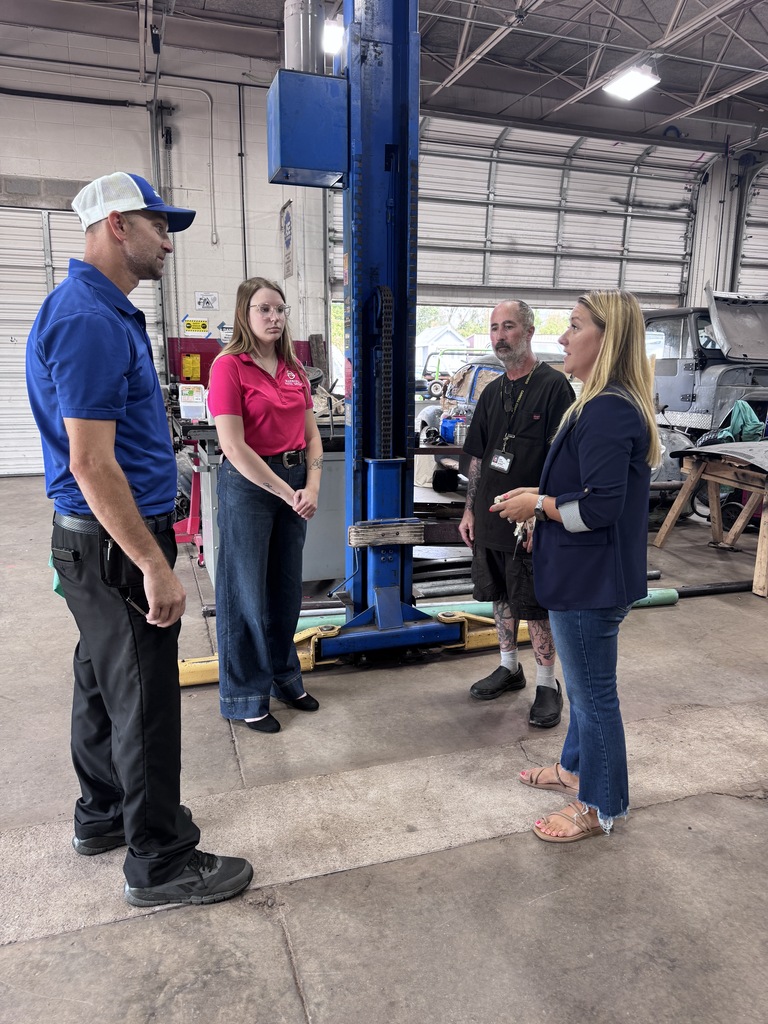 adults speaking in auto shop