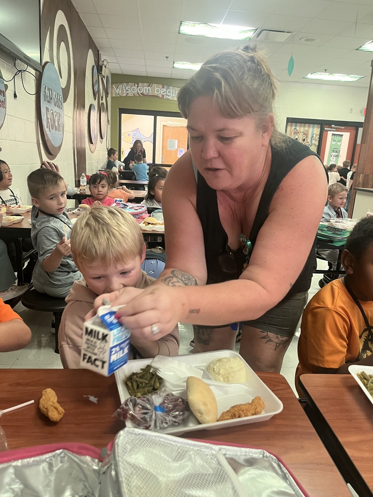 custodian helping child at lunch