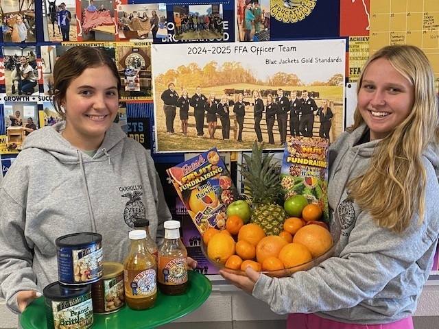 2 ffa students holding fruit/nuts