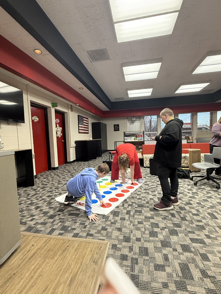 Three students playing Twister. 
