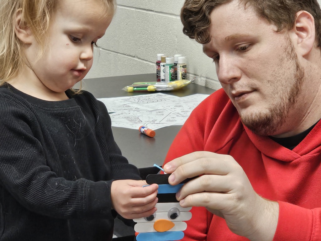 father and daughter making a snowman craft together