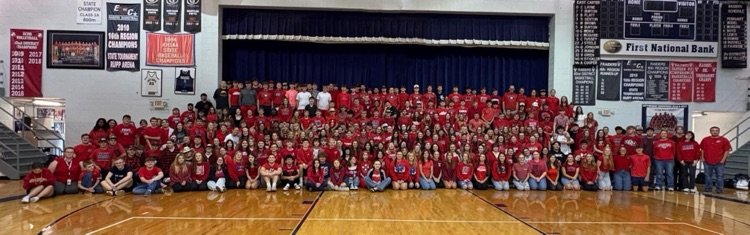 400 or more students wearing red in front on stage 