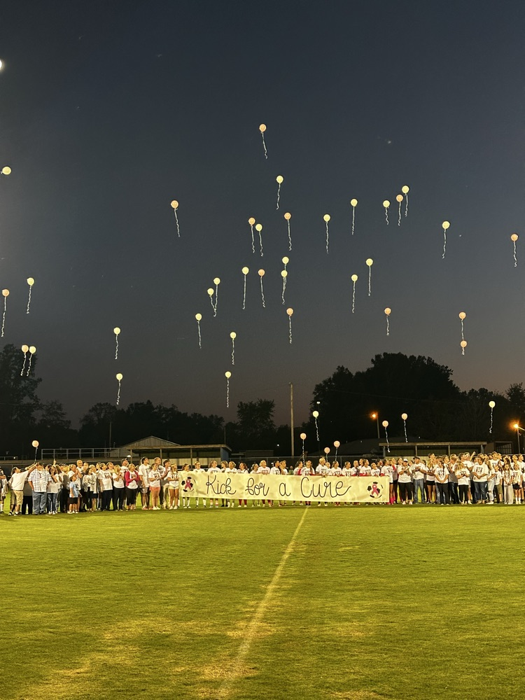 crowd holding Kick for a Cure banner and releasing balloons.