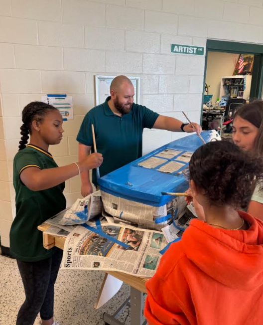 students painting a boat