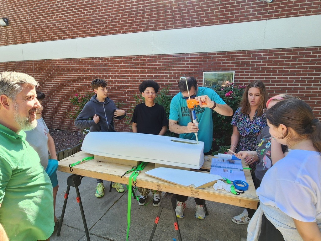 students and staff working on boat