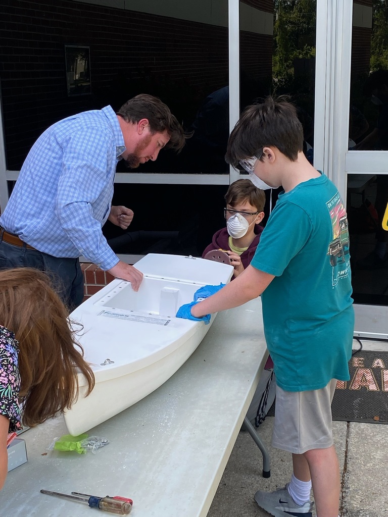 students and teachers building boats