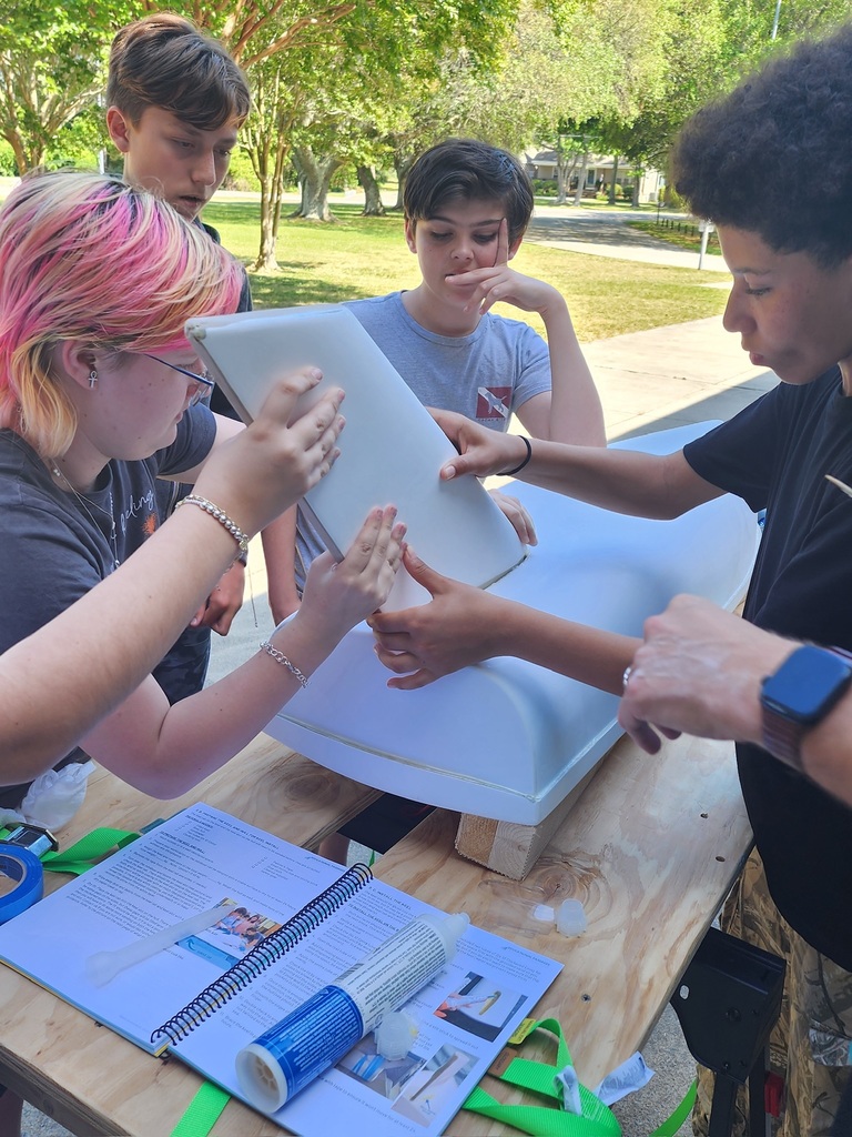 students putting the rudder on a boat