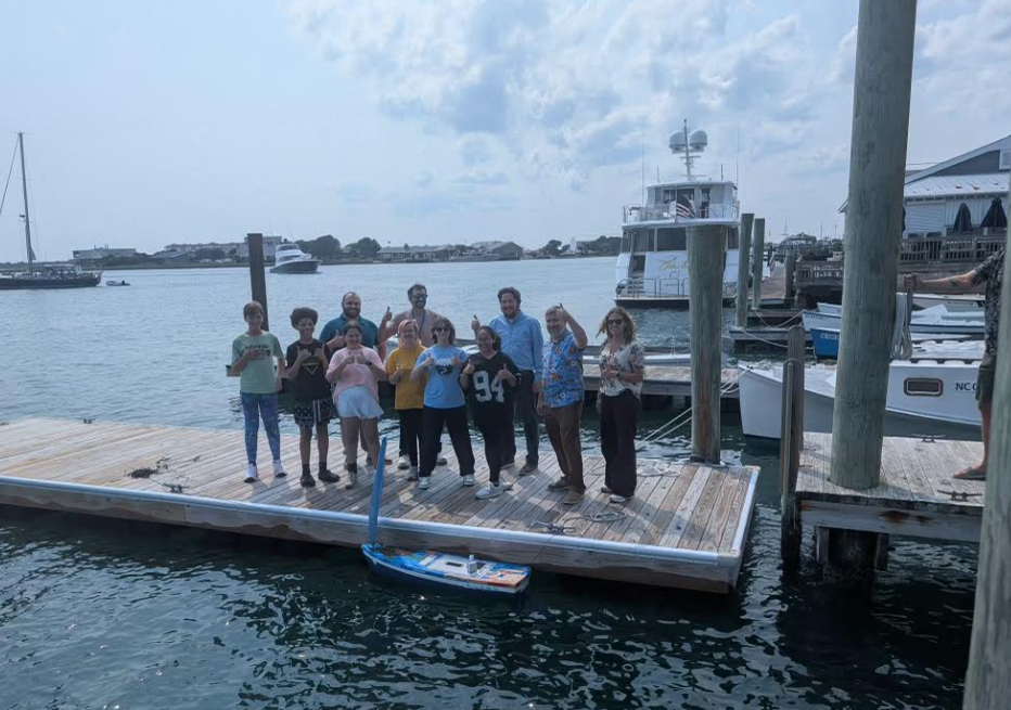 Students testing bouyancy of boat at dock