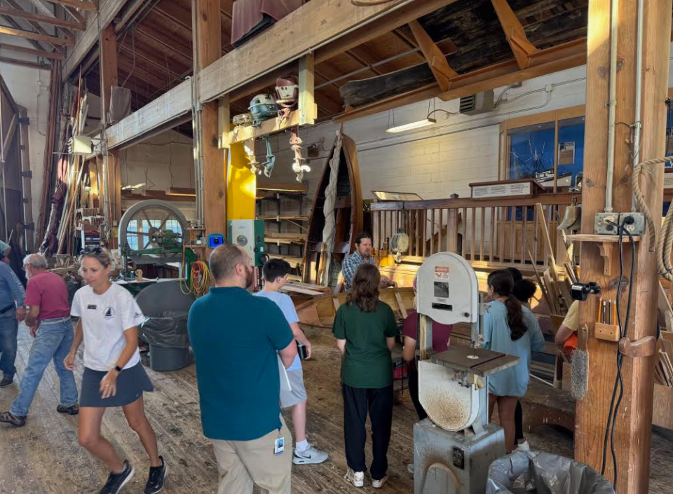 students working at a boat building place in town