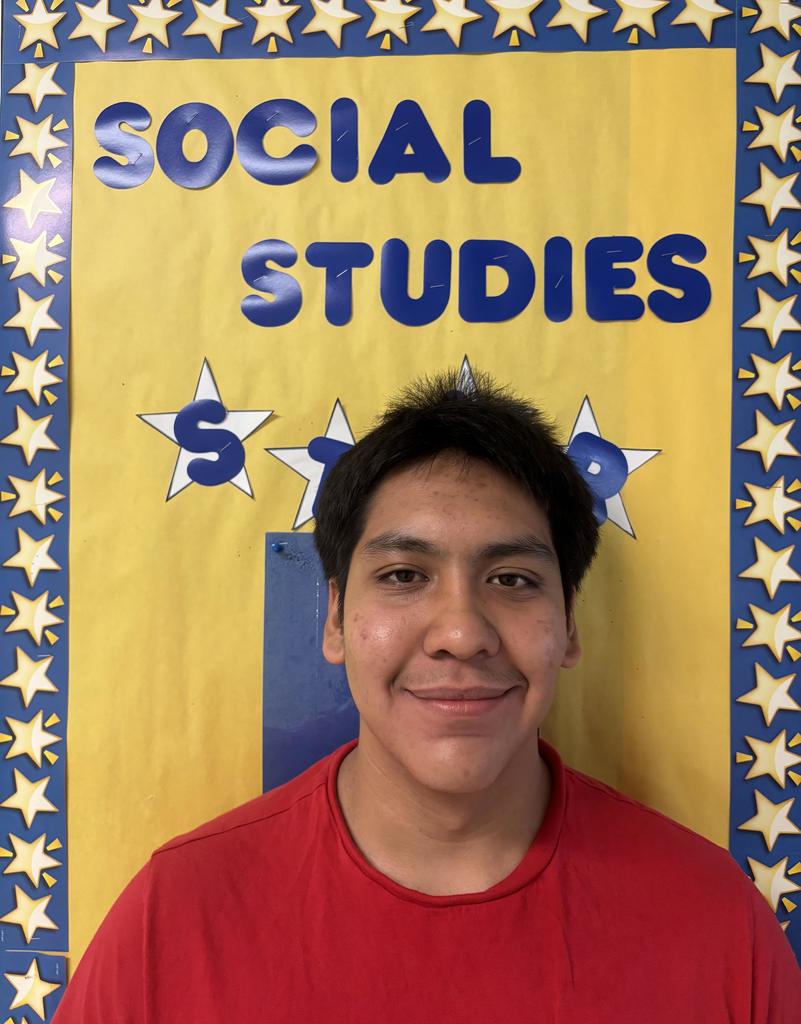 Hilario Banda-Hernandez is this week's Social Studies Student of The Week! He stands in front of the "Social Studies Star" bulletin board.