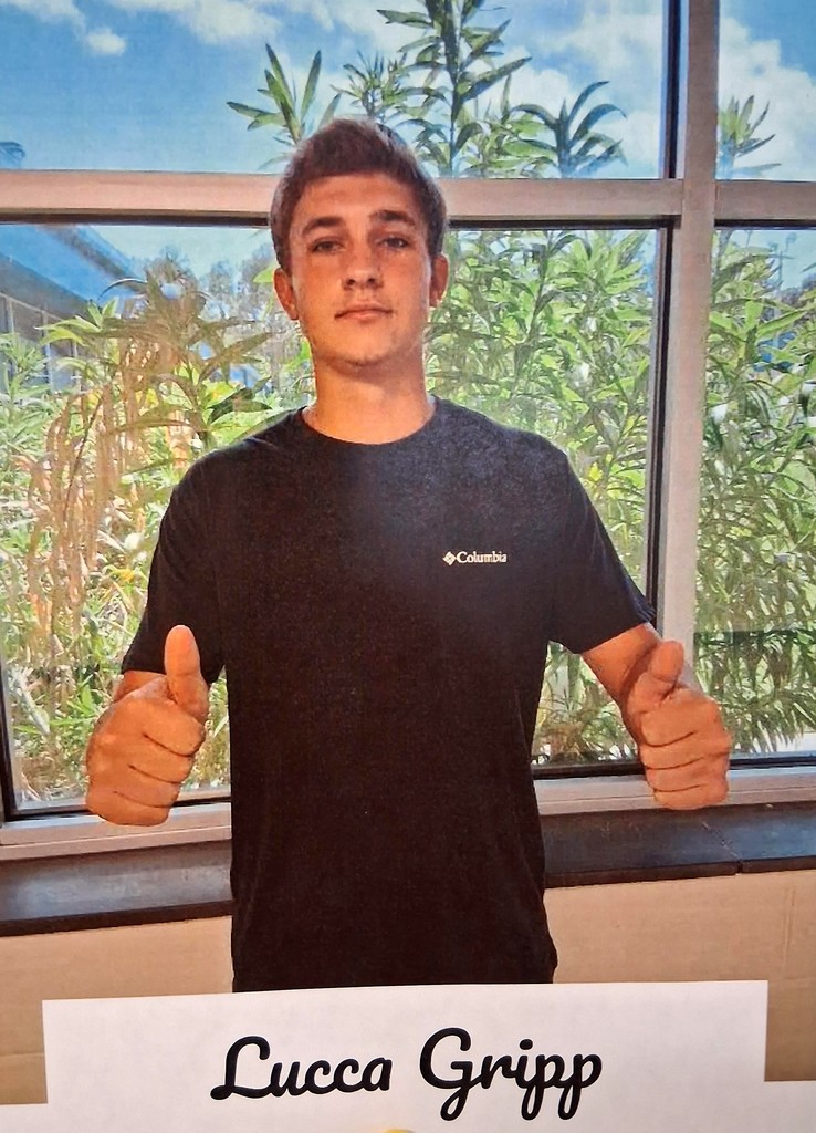 Lucca stands in front of a window giving two thumbs up.