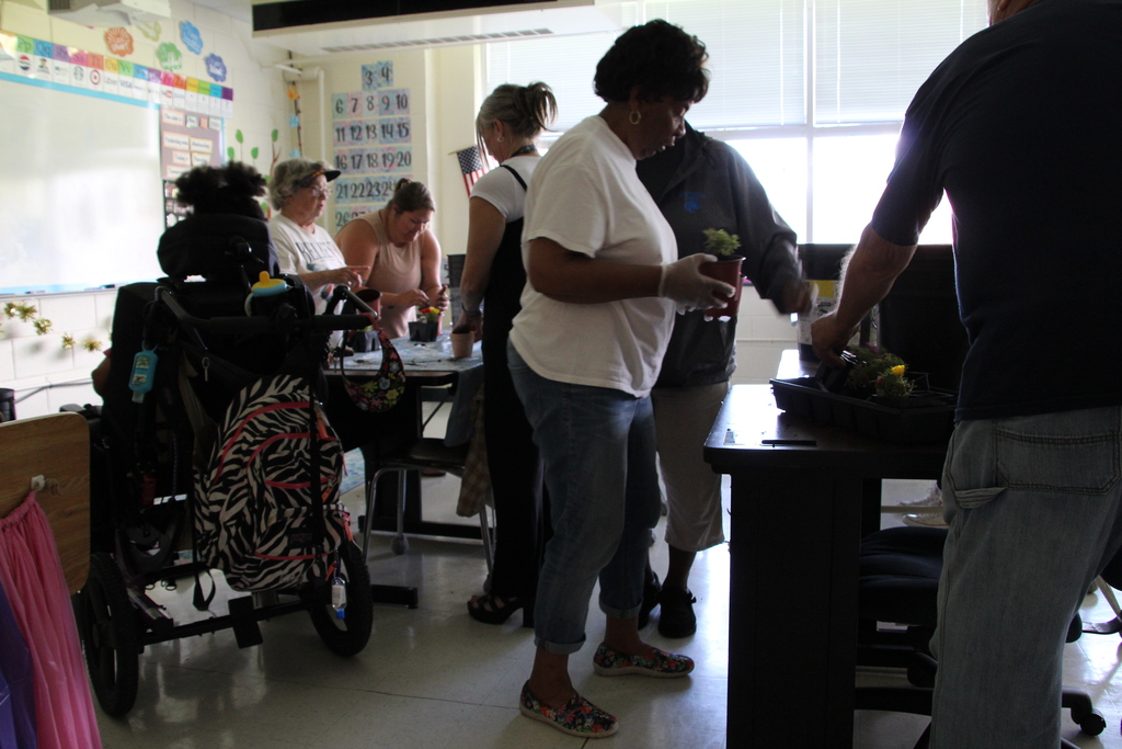 The class plants flowers with the help of volunteers and staff.