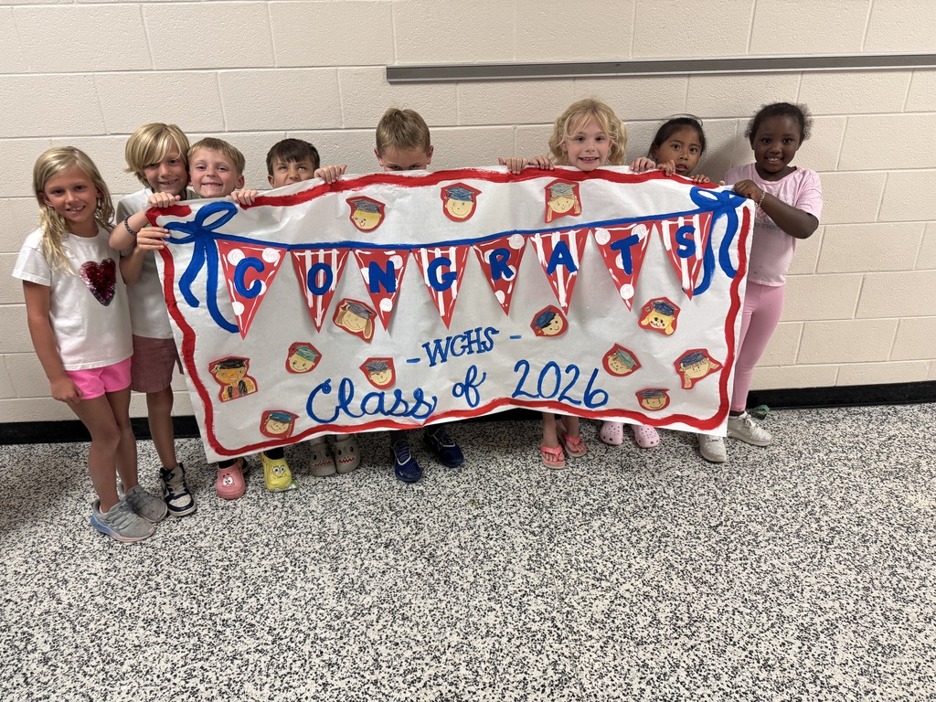 students holding graduation banner