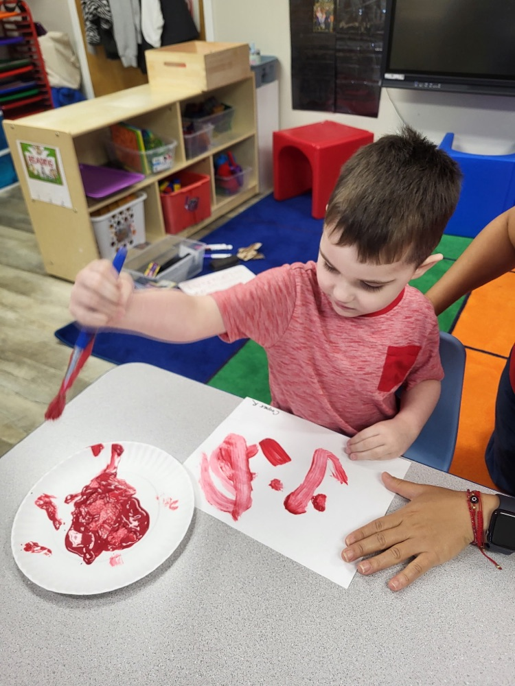 child painting with red paint 