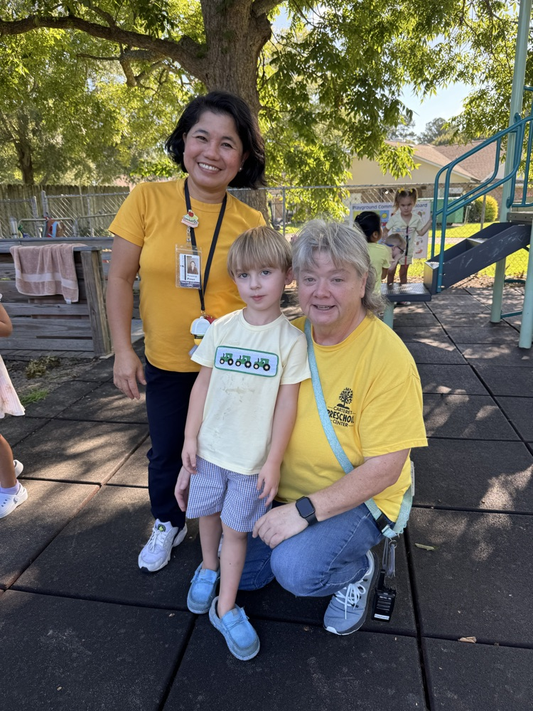 child smiling with two adults 