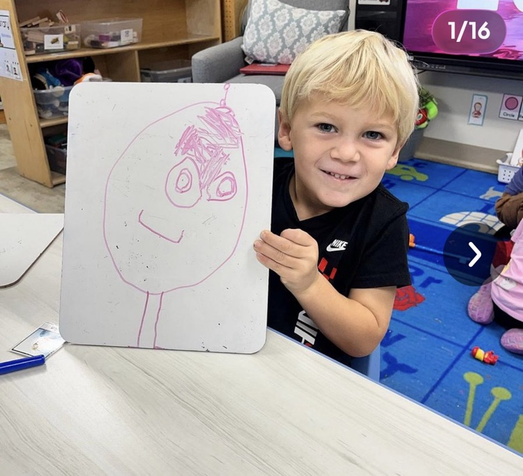 little boy holding picture he drew