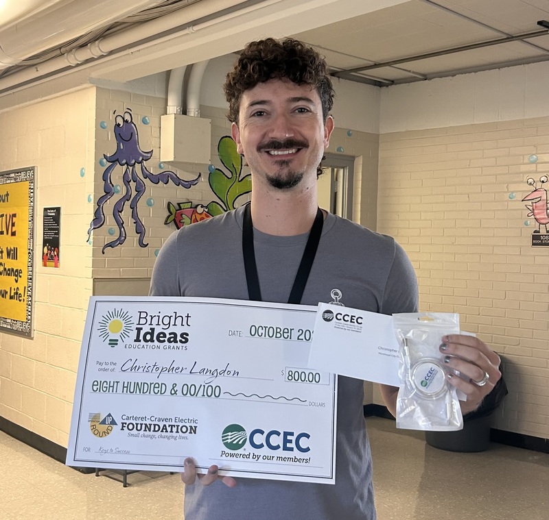 Picture of Mr. Langdon holding a Bright Ideas check for his grant "Keys to Success"