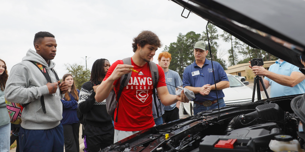 Adulting 101: Brooks Soape checking the oil in a vehicle