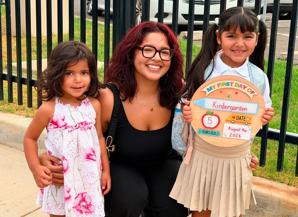 Mother poses with her two children for the first day of school