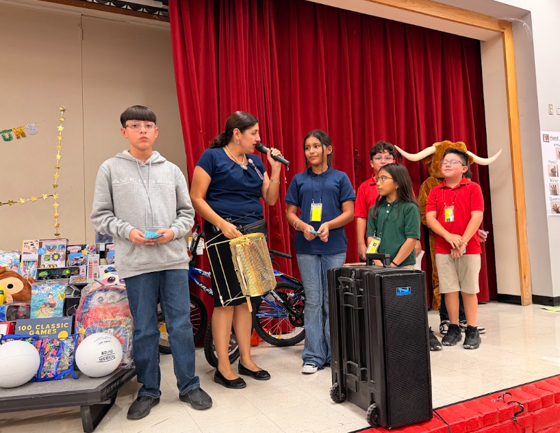 lady with a mic is talking to students on stage