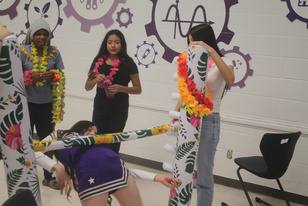 Students taking part in limbo and coconut bowling games at the luau.