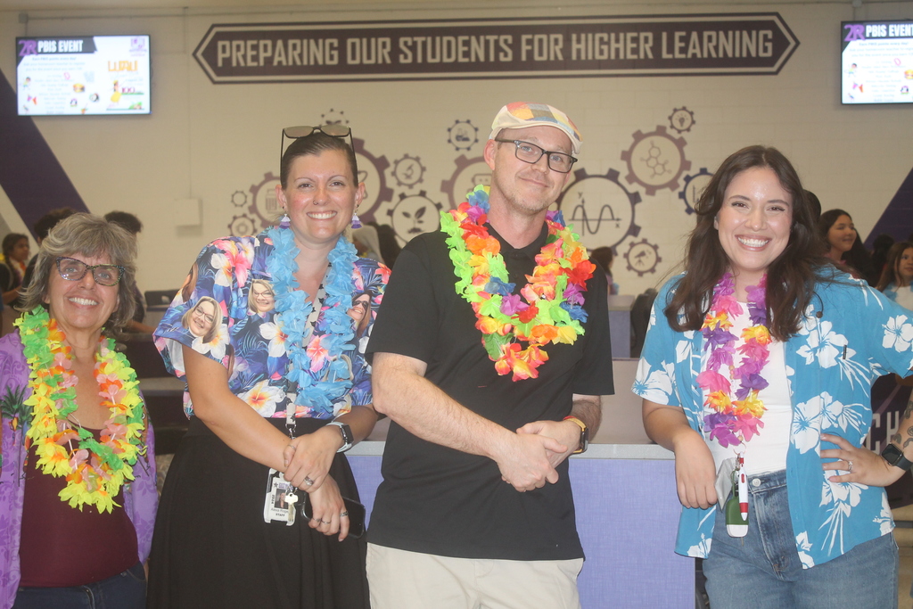 School staff smiling together while supporting students at the PBIS Luau.