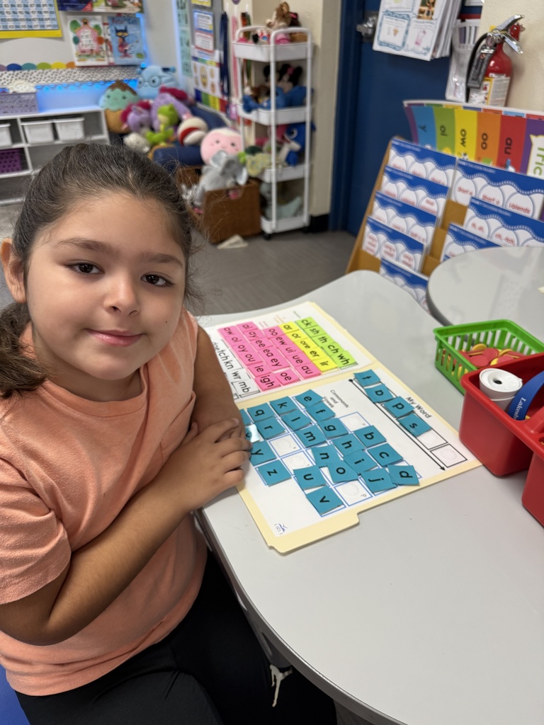 Students working with word mats that include letters, diagraphs, etc.