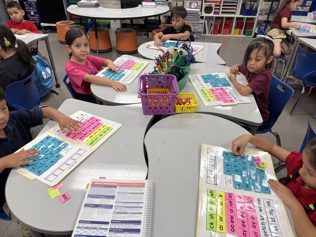 Students working with word mats that include letters, diagraphs, etc.