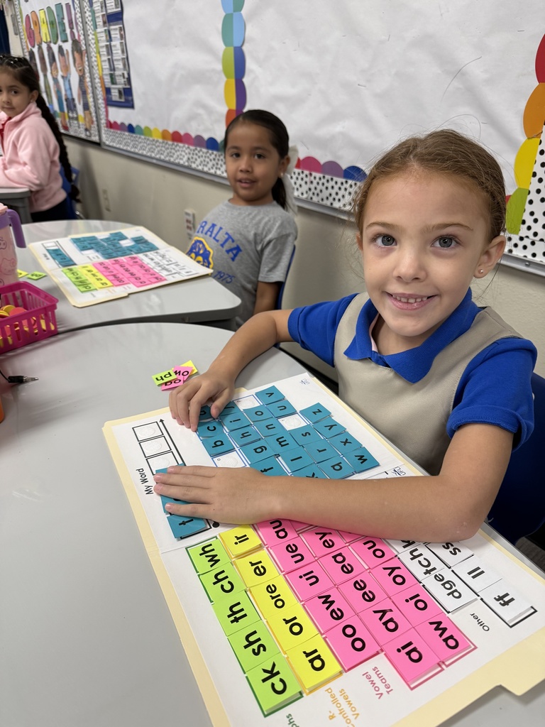 Students working with word mats that include letters, diagraphs, etc.