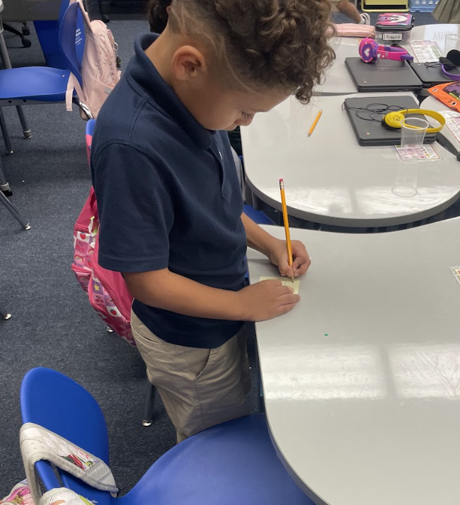 Student writing on a sticky note