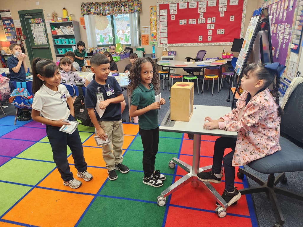 2nd grade students lined up to place their vote in a ballot box.