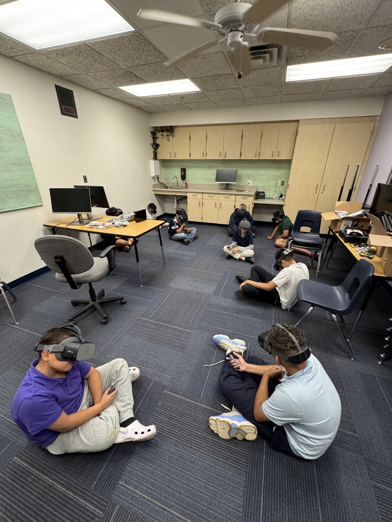 Students sitting on the floor trying out VR headsets