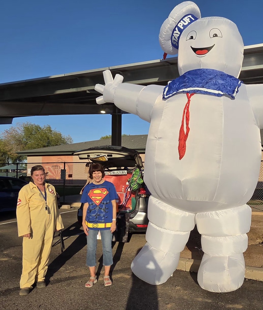 teacher in a Ghost Buster costume, teacher in a Superman costume, and a giant inflatable Stay Puft Marshmallow Man