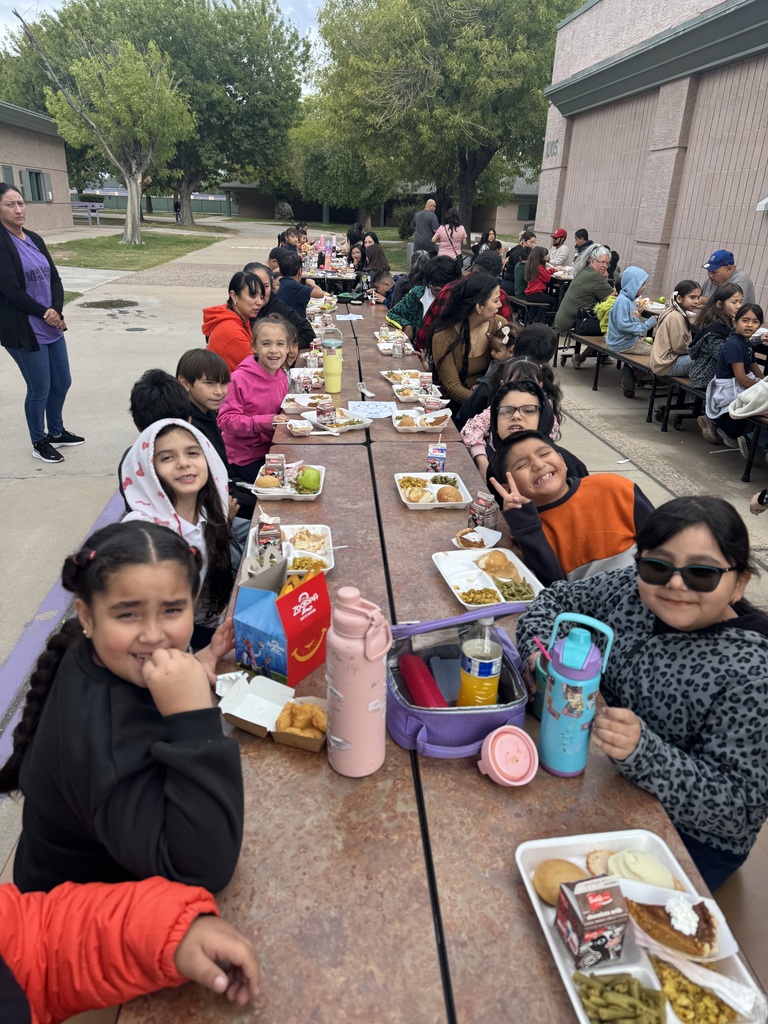 students and parents eating a thanksgiving meal outside