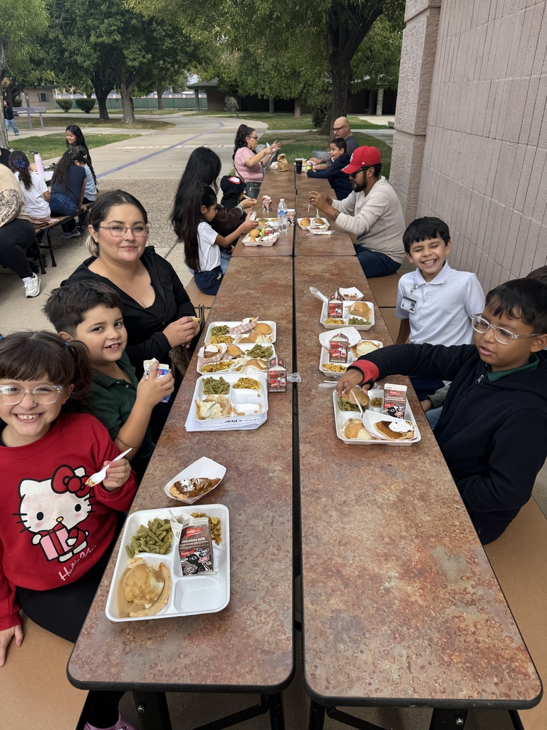 students and parents eating a thanksgiving meal outside